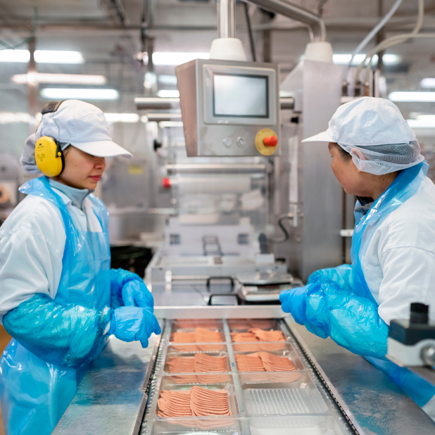 Bild på två arbetare som jobbar med att paketera kött. Här har du chans att få jobb snabbt, en bra lön – och har stora karriärmöjligheter.
